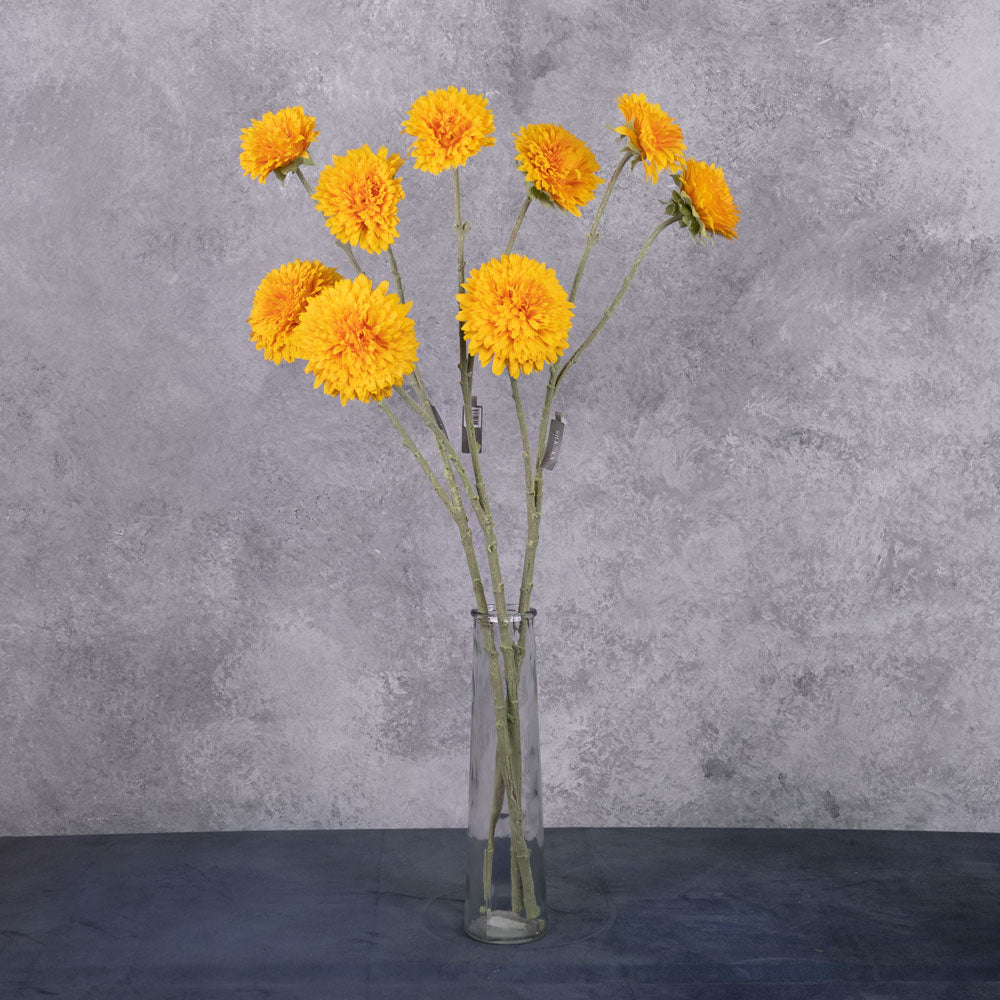 A collection of 3 faux sunflower stems displayed in a glass vase