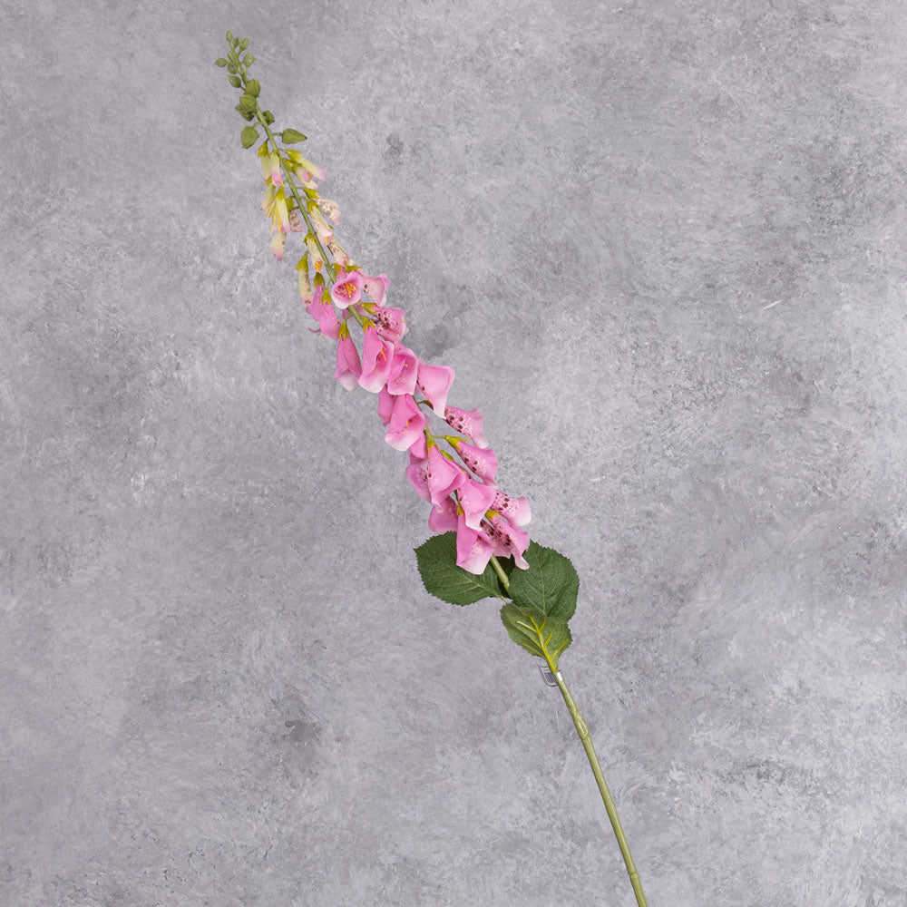 A single faux, pink foxglove stem close up