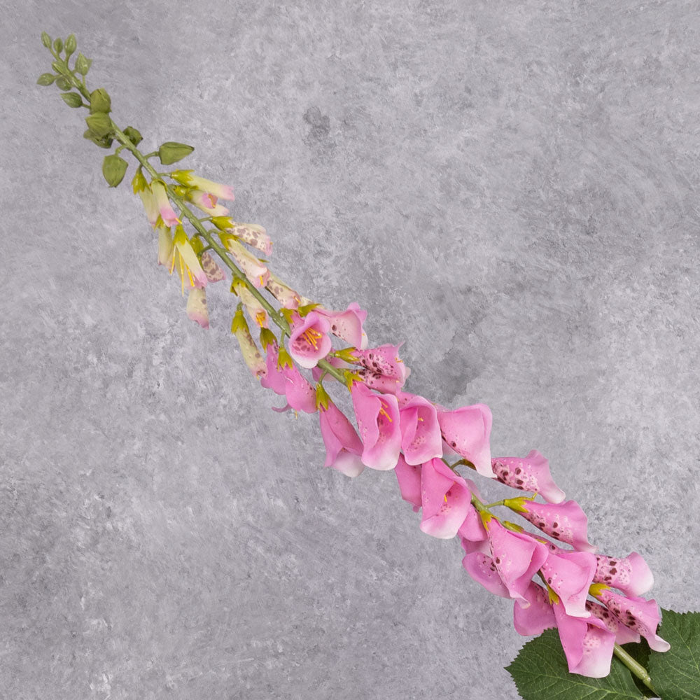 A single faux, pink foxglove stem close up